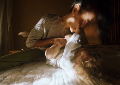 a woman laying on top of a bed next to a child