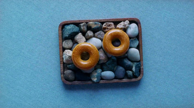 a couple of doughnuts sitting on top of a pile of rocks