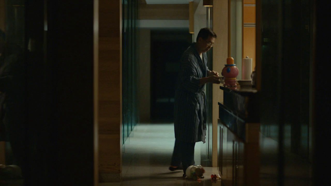 a man standing in a hallway holding a vase