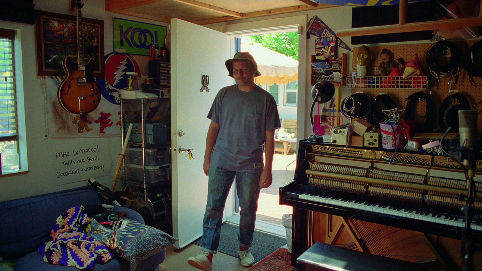 a man standing in front of a piano in a room