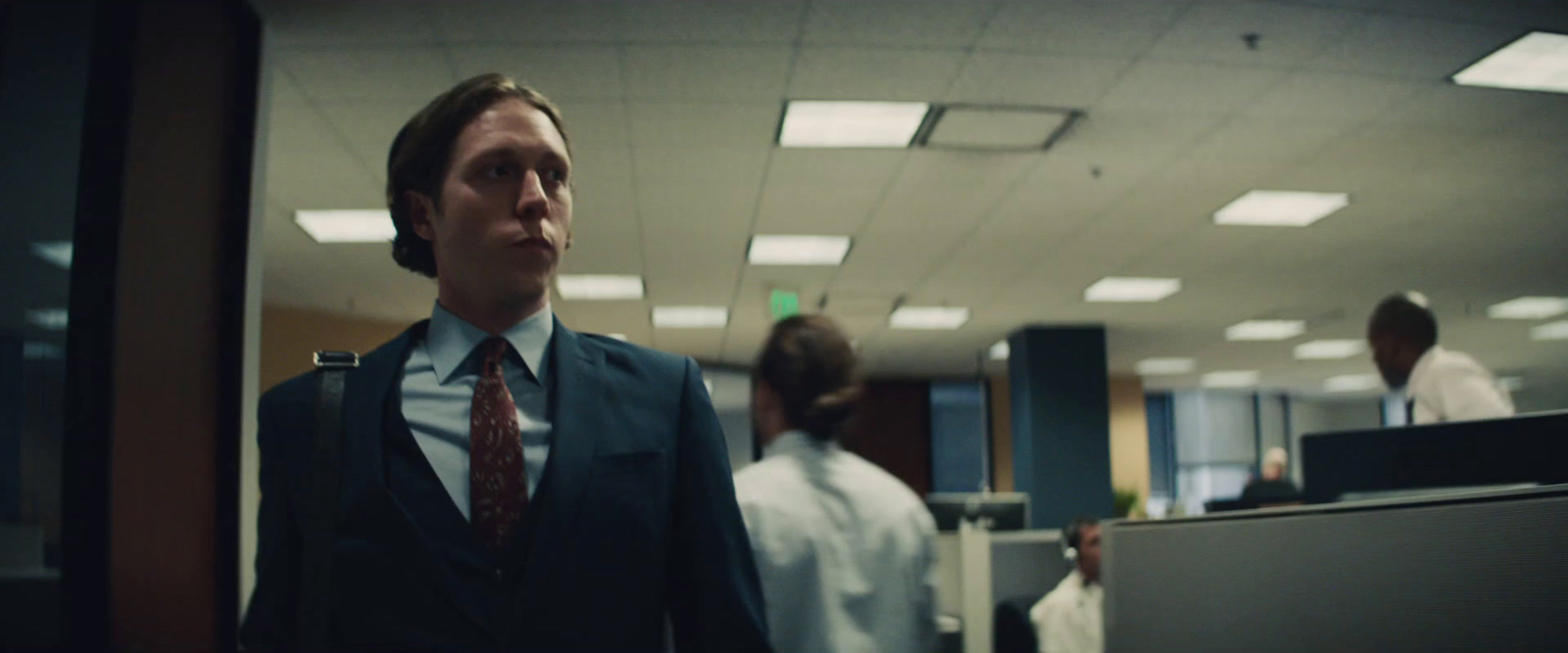 a man in a suit and tie standing in an office