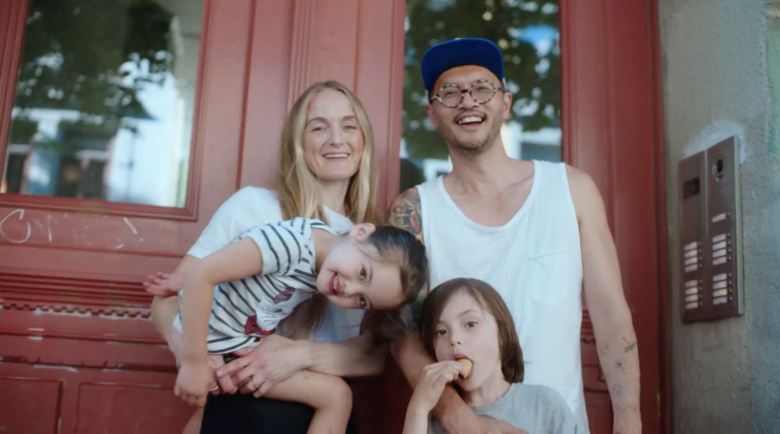 a family poses for a picture in front of a red door