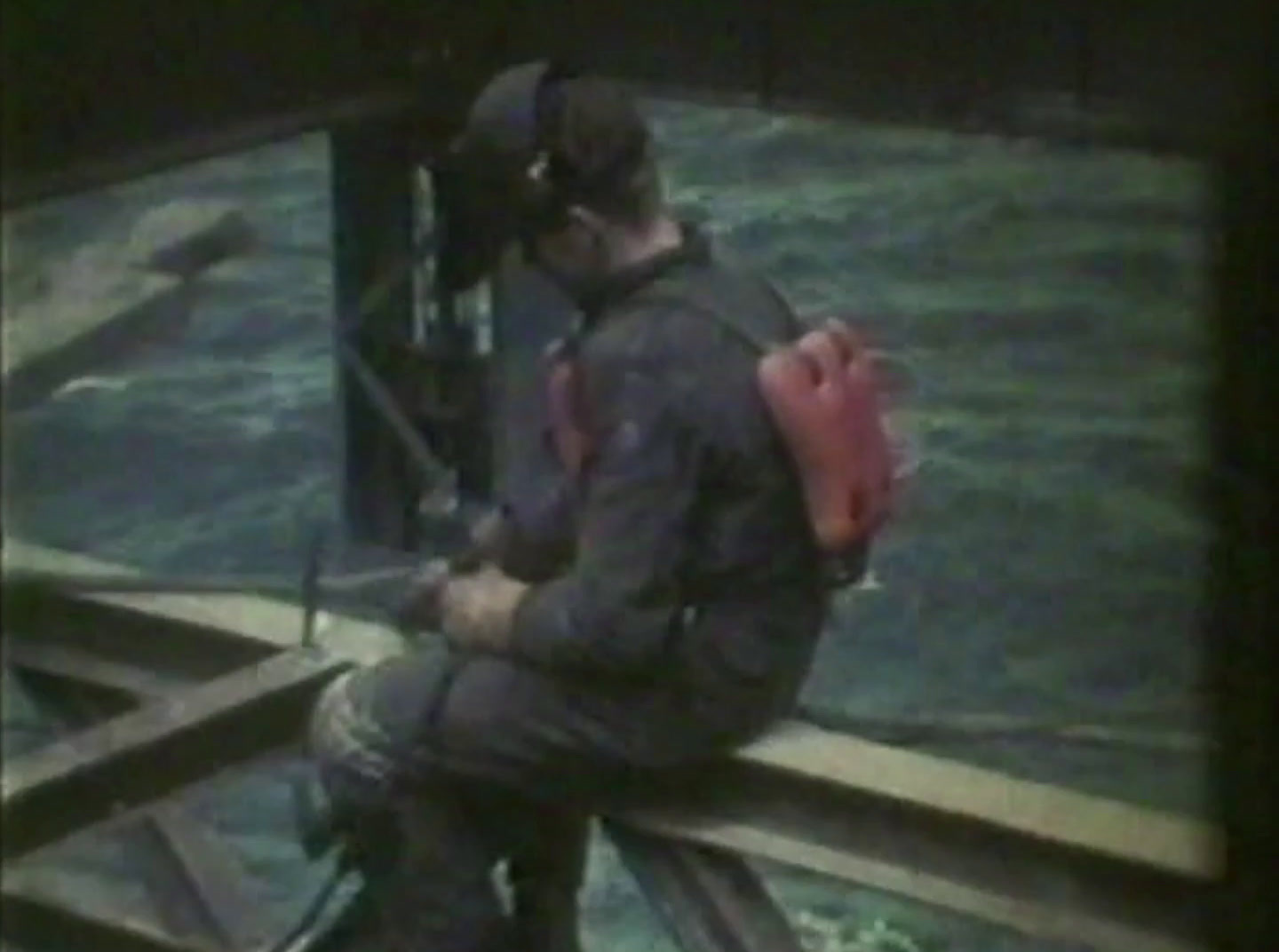 a man sitting on a dock with a red backpack