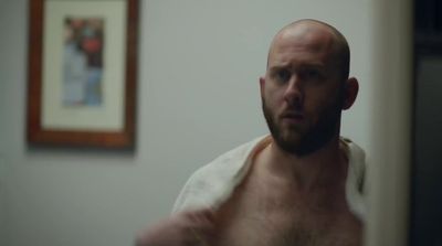 a bald man with a towel around his neck