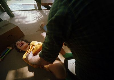 a young child laying on the floor next to a man