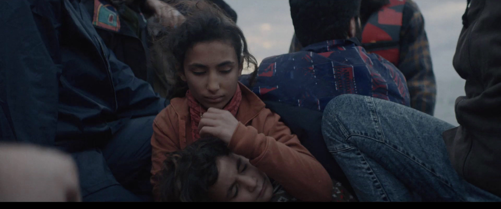 a young girl sitting in a crowd of people