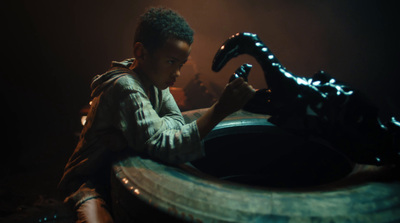 a young man sitting in front of a dragon statue