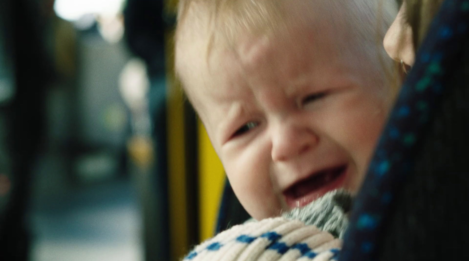 a baby crying while sitting on a bus