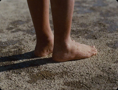 a close up of a person's bare feet in the sand