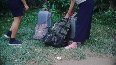 a couple of people standing next to a pile of luggage