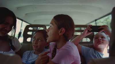 a group of children sitting in the back of a car