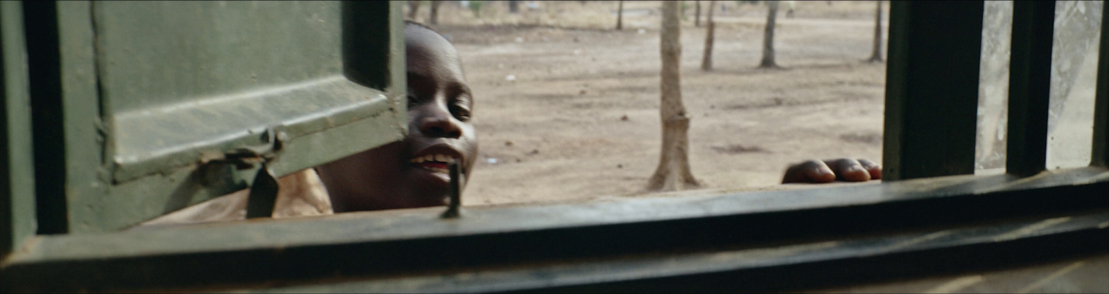 a man looking out of a window at a forest