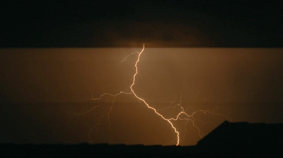 a lightning bolt is seen in the dark sky