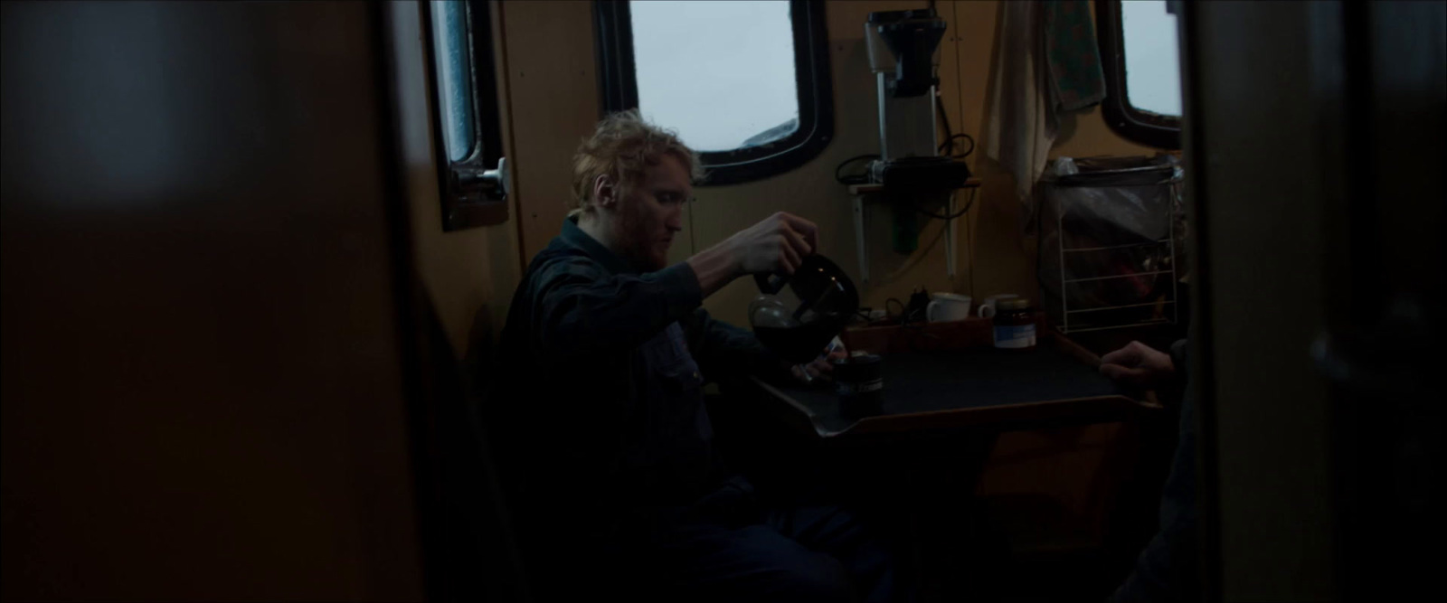 a man sitting at a table with a sewing machine