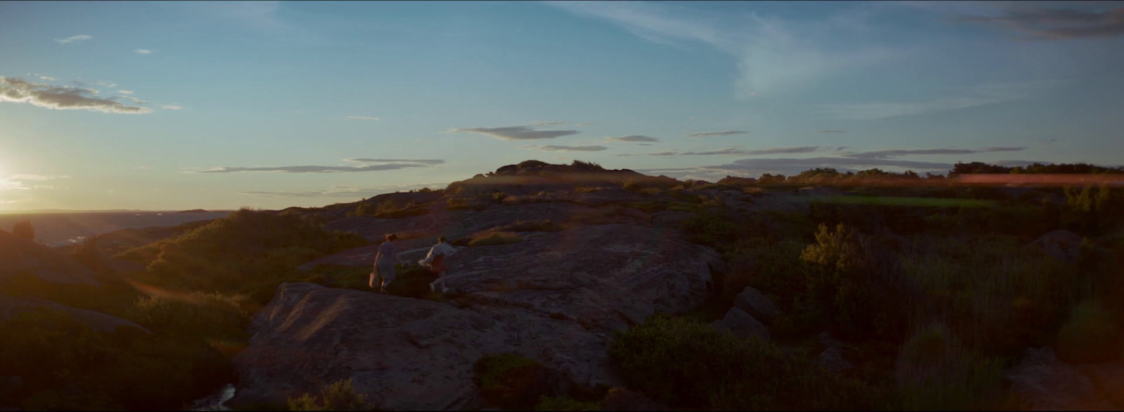 a person sitting on top of a large rock