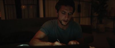 a man sitting at a table writing on a piece of paper