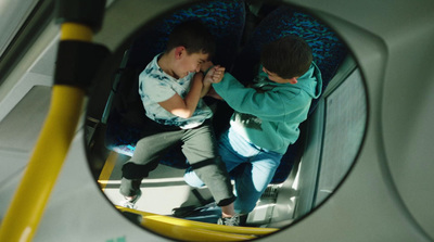 a couple of kids sitting on top of a bus