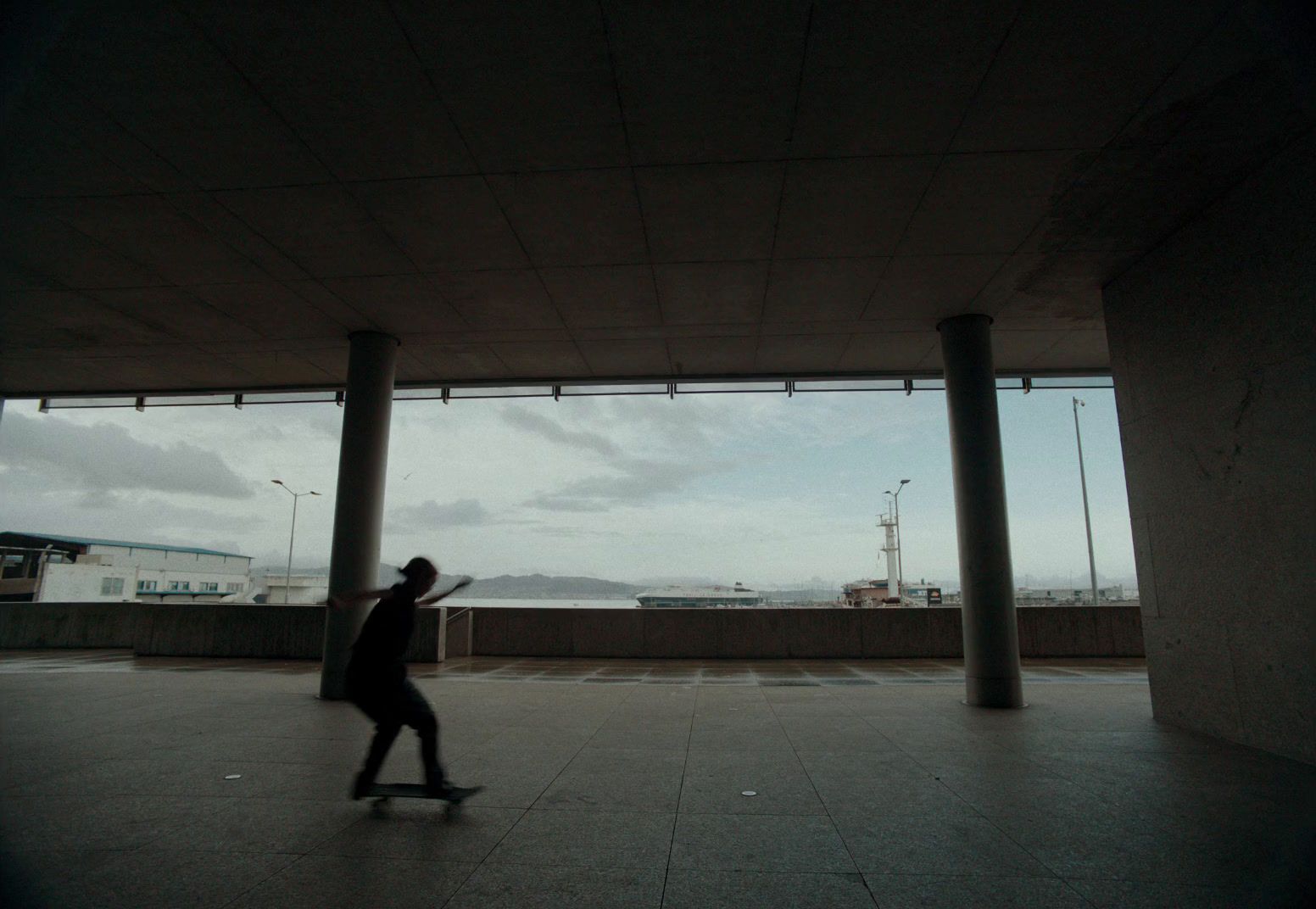 a man riding a skateboard under a bridge