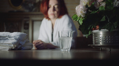 a woman sitting at a table with a glass of water