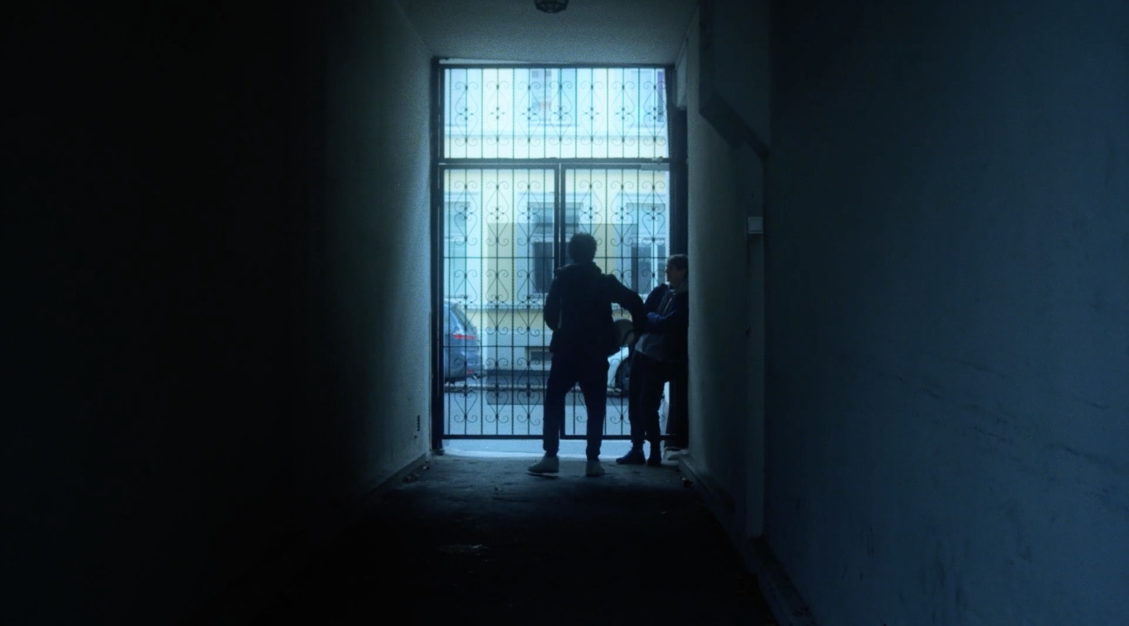 a couple of people that are standing in a hallway