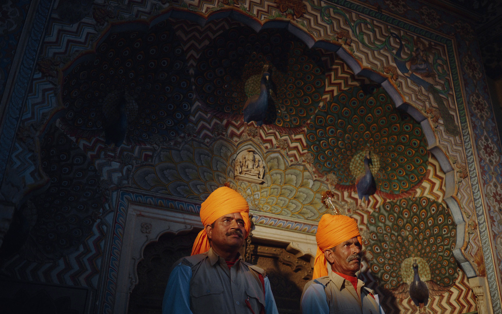 two men in turbans standing in front of a wall