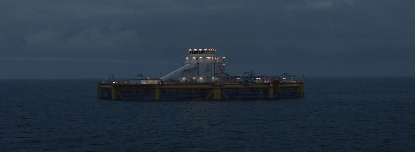 an oil rig in the middle of the ocean at night