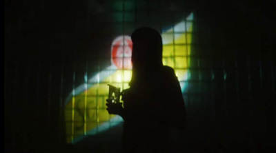 a person standing in a dark room holding a camera