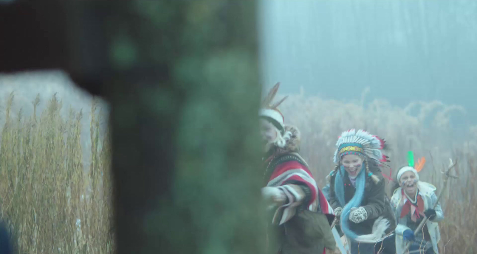 a group of native americans walking through a field