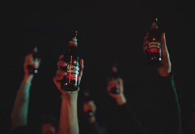 a group of people holding up beer bottles