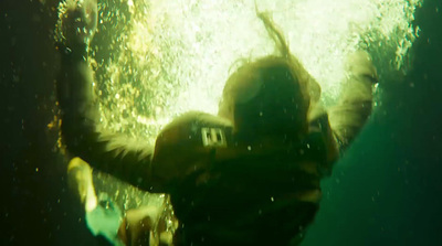 a person standing under water with their arms in the air