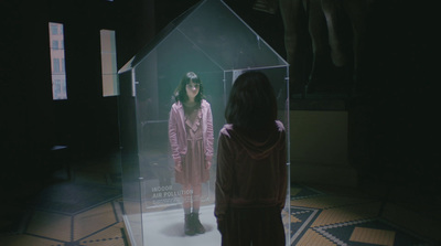 a woman standing in front of a glass display case