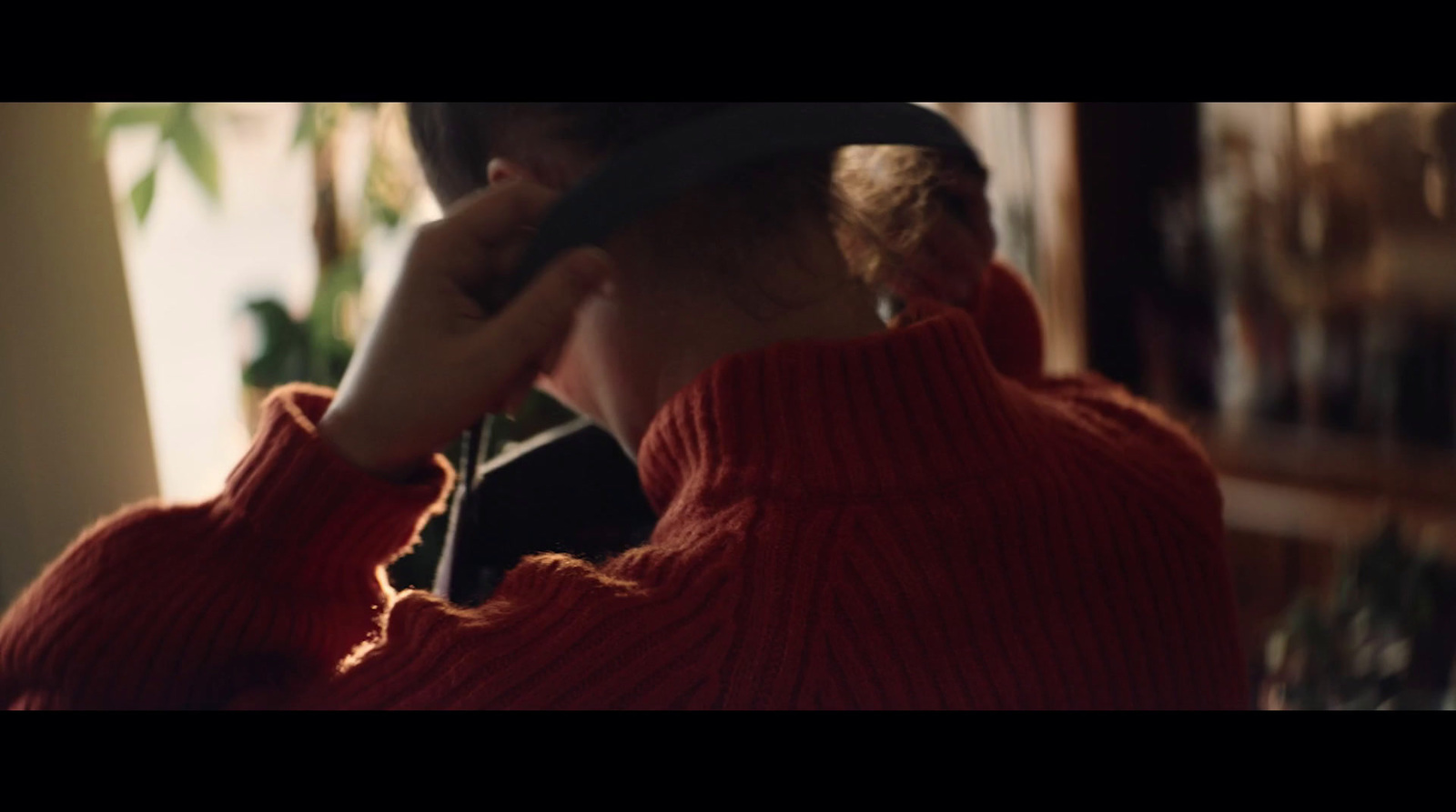 a woman in a red sweater is talking on a cell phone