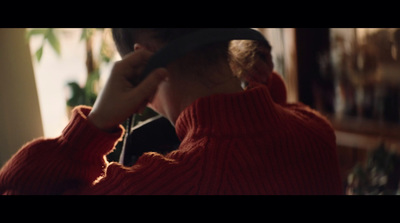 a woman in a red sweater is talking on a cell phone