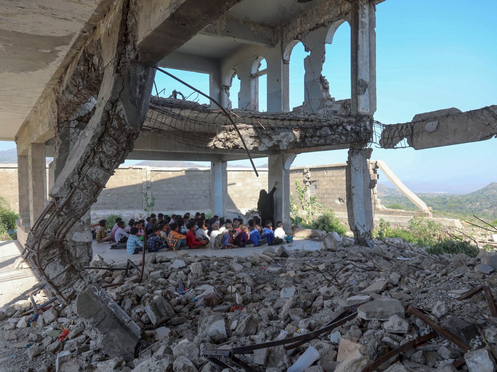 a group of people sitting on a pile of rubble