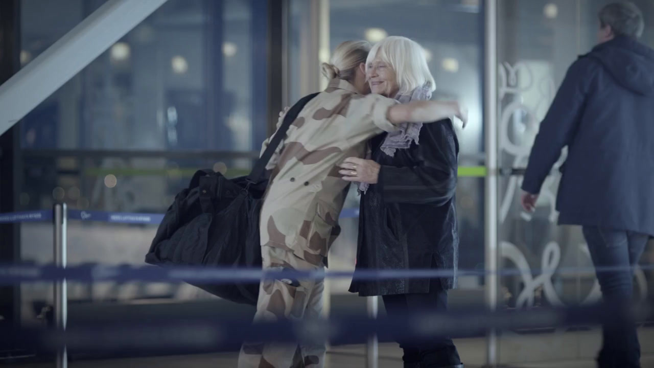 a woman hugging another woman in front of a building