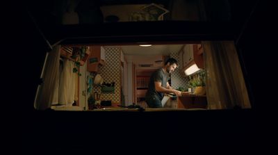 a man standing in a kitchen next to a window