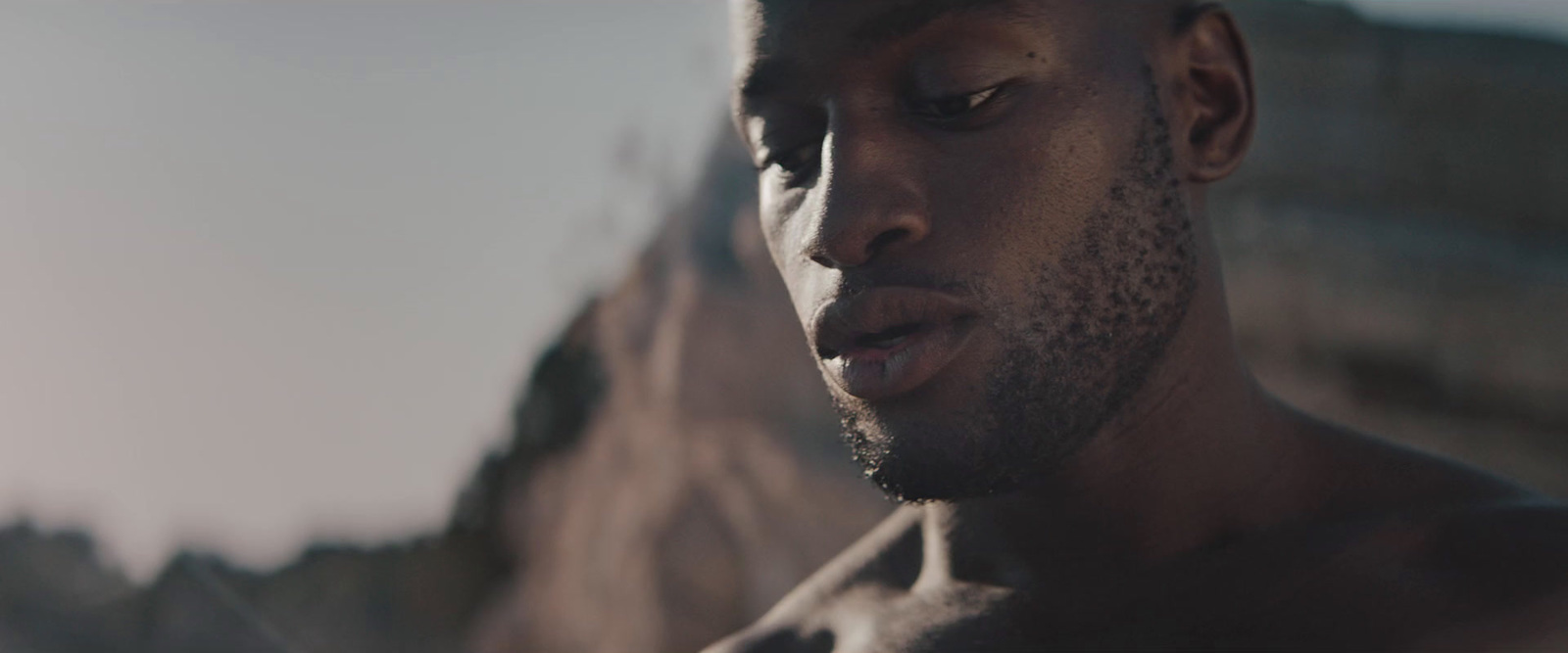 a close up of a shirtless man looking at his cell phone