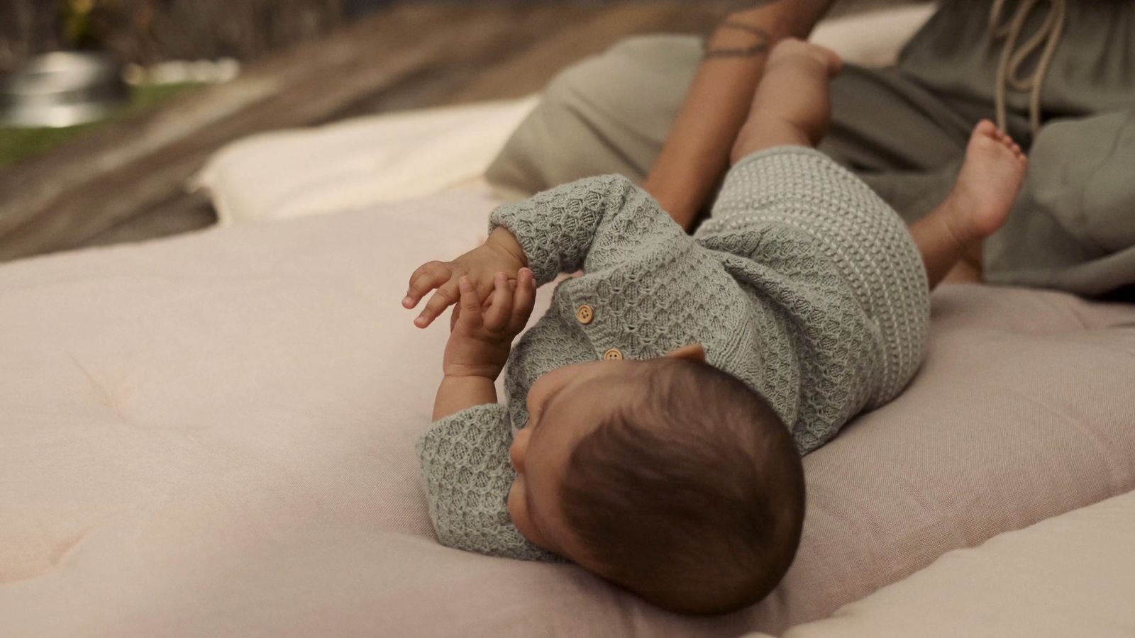 a baby laying on its back on a bed