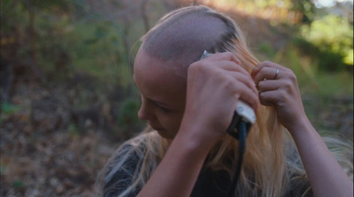 a woman combing her hair in the woods