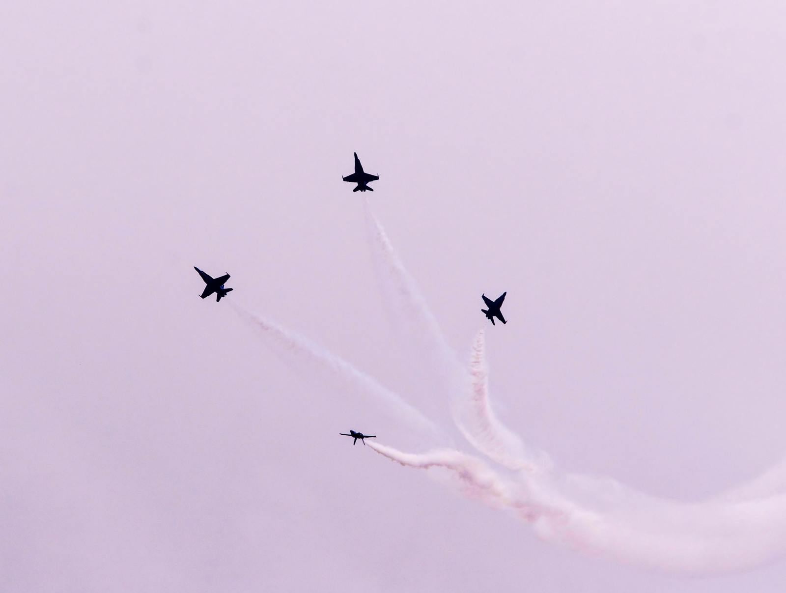 a group of jets flying through a cloudy sky