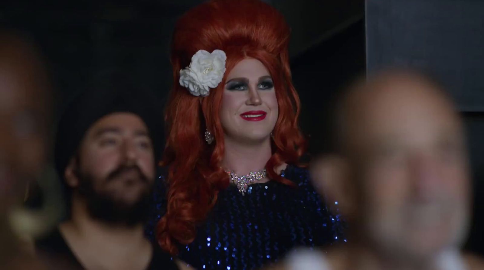 a woman with red hair and a flower in her hair