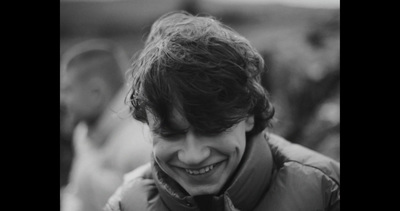 a black and white photo of a man smiling