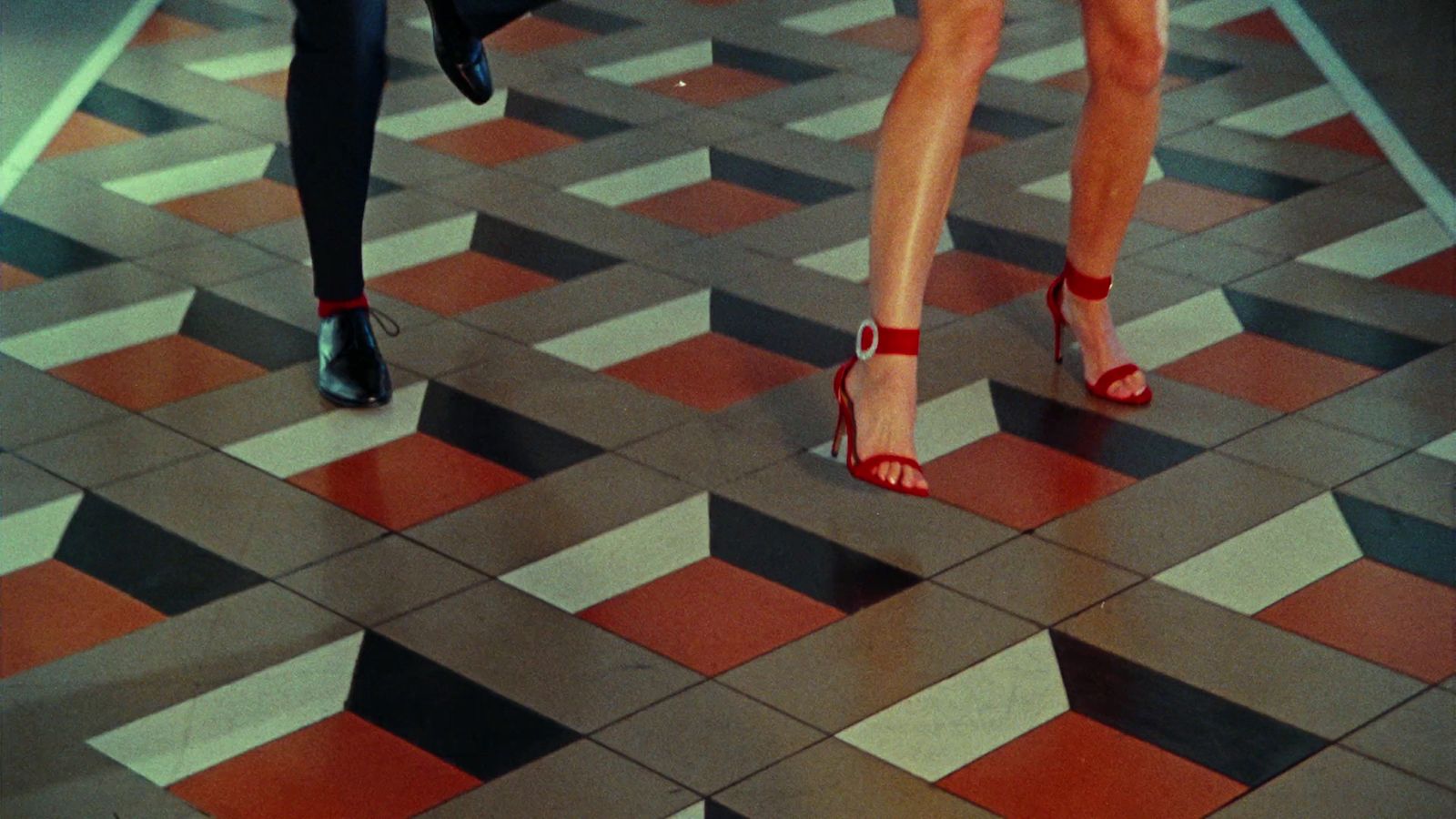 a couple of women walking across a tiled floor