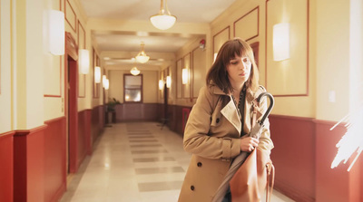 a woman standing in a hallway holding an umbrella