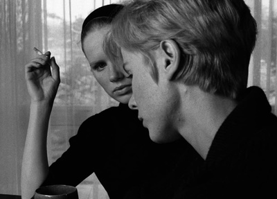 a woman sitting at a table smoking a cigarette