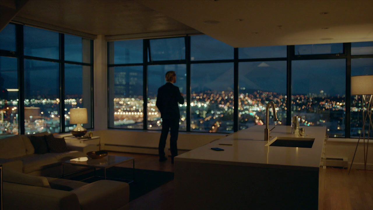 a man standing in a living room looking out a window