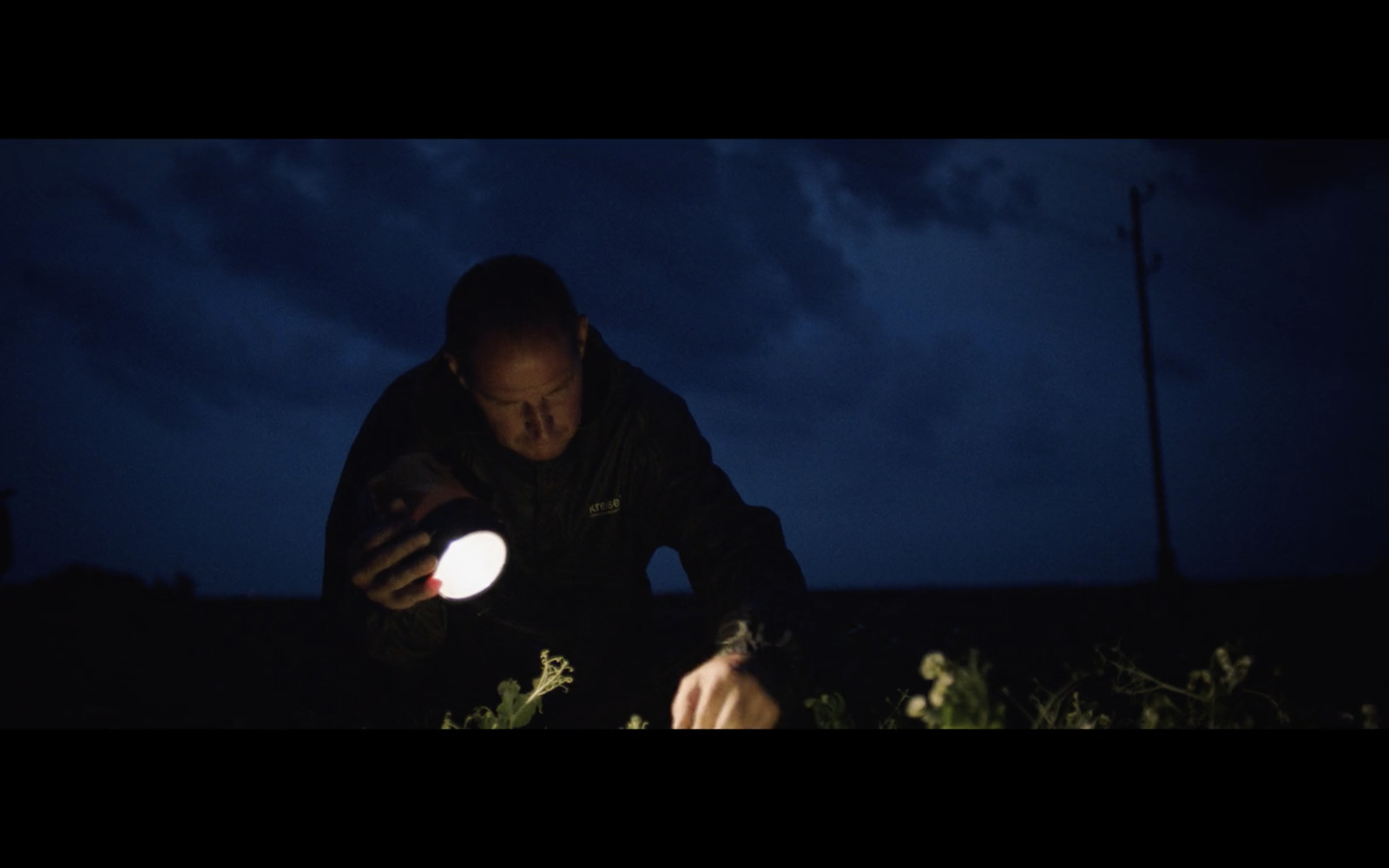 a man holding a white frisbee at night