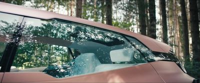 a pink car with trees in the background