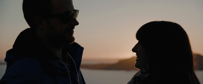 a silhouette of a couple looking at each other at sunset