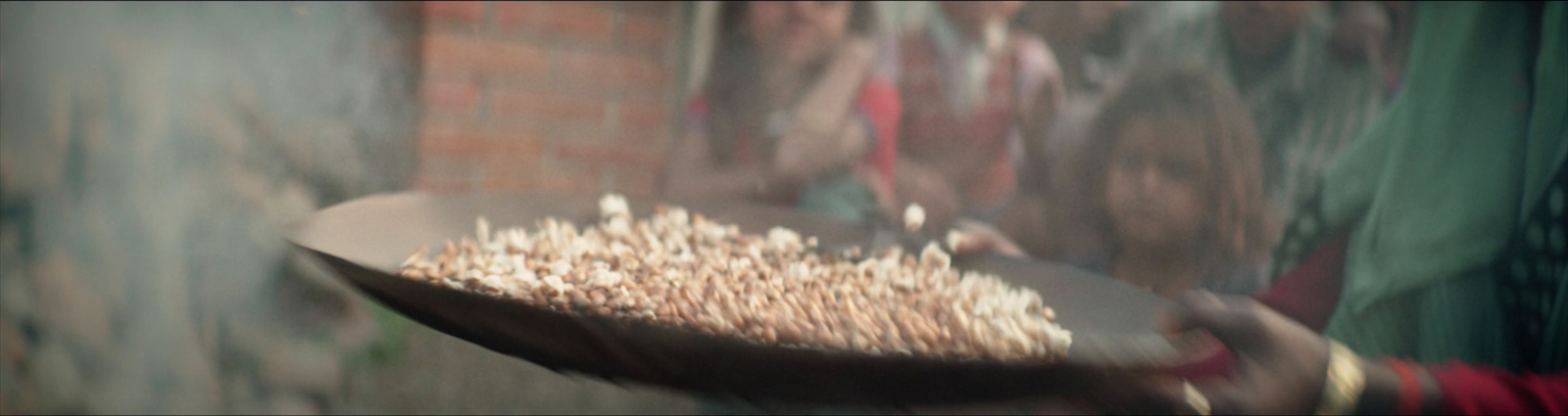 a person holding a tray of food in front of a brick wall